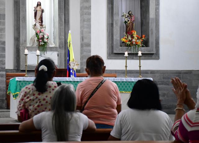 Locals pray during a mass within the National Day of Prayer for the quake victims in Valencia, Carabobo state, Venezuela, following twin earthquakes, on June 28, 2026. Volunteers and emergency brigades with rescue dogs continue lifting mountains of rubble on in search of survivors of the twin earthquake that struck Venezuela four days ago, which completely brought down nearly 200 buildings and left at least 1,450 dead and tens of thousands missing. (Photo by Jacinto OLIVEROS / AFP)