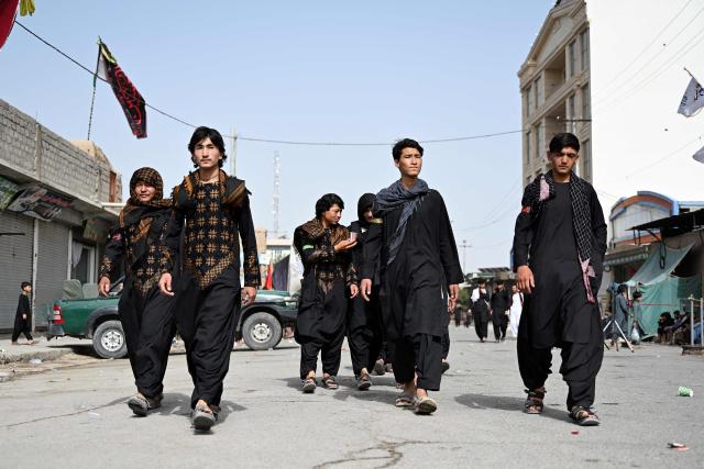 This photograph taken on June 26, 2026 shows Afghan Hazara Shia muslims walking towards a mosque to mark Ashura on the tenth day of the Islamic month of Muharram, in Afghanistan's Kandahar province. (Photo by Sanaullah SEIAM / AFP)