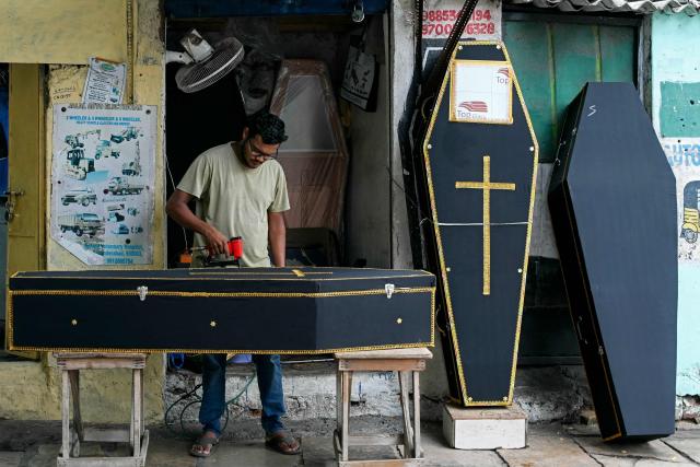 A man makes a wooden coffin at a workshop in Hyderabad on June 29, 2026. (Photo by Noah SEELAM / AFP)