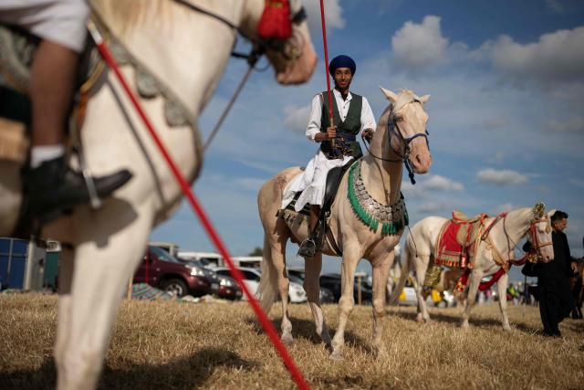 Team members with the Khari Shreef Club prepare to compete at the Bury Championship Neza Bazi event in Unsworth, near Bury, northern England on June 28, 2026. Neza Bazi, also known as tent pegging, sees riders on horseback use a lance or sword to strike and pick up small targets from the ground whilst at full gallop. The sport is believed to have originated in the Indian subcontinent during the Middle Ages. It is one of only ten equestrian sports officially recognised by the International Equestrian Federation. (Photo by Oli SCARFF / AFP)