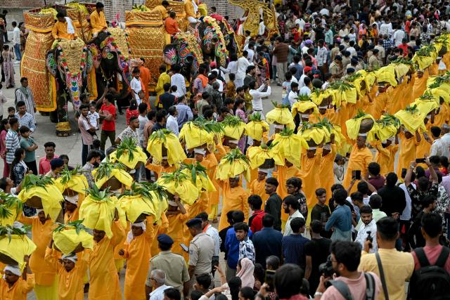 Mahouts ride decorated elephants as devotees take part in Jal Yatra, a Hindu religious procession from Lord Jagannath temple to Sabarmati riverfront in Ahmedabad on June 29, 2026. (Photo by Shammi MEHRA / AFP)