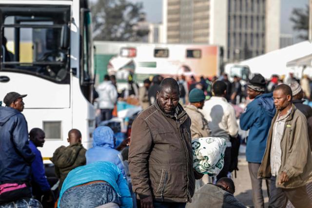 Undocumented migrants queue to board the last buses leaving the Durban Drive In in central Durban, on June 29, 2026. South Africans President Cyril Ramaphosa vowed on June 25 to crush any attempts to destabilise the nation during planned anti-immigrant marches next week, amid a wave of xenophobia. Citizen-led groups have set Tuesday 30 as a deadline for undocumented foreigners to leave and called for nationwide marches against illegal immigration, marking a crescendo in months of protests that have at times turned violent. (Photo by Marco Longari / AFP)