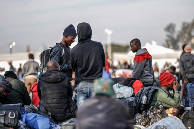 Undocumented migrants queue to board the last buses leaving the Durban Drive In in central Durban, on June 29, 2026. South Africans President Cyril Ramaphosa vowed on June 25 to crush any attempts to destabilise the nation during planned anti-immigrant marches next week, amid a wave of xenophobia. Citizen-led groups have set Tuesday 30 as a deadline for undocumented foreigners to leave and called for nationwide marches against illegal immigration, marking a crescendo in months of protests that have at times turned violent. (Photo by Marco Longari / AFP)