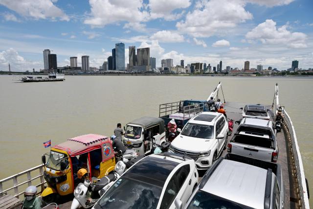 Ferries transport passengers and vehicles across the Mekong River in Phnom Penh on June 29, 2026. (Photo by TANG CHHIN Sothy / AFP)