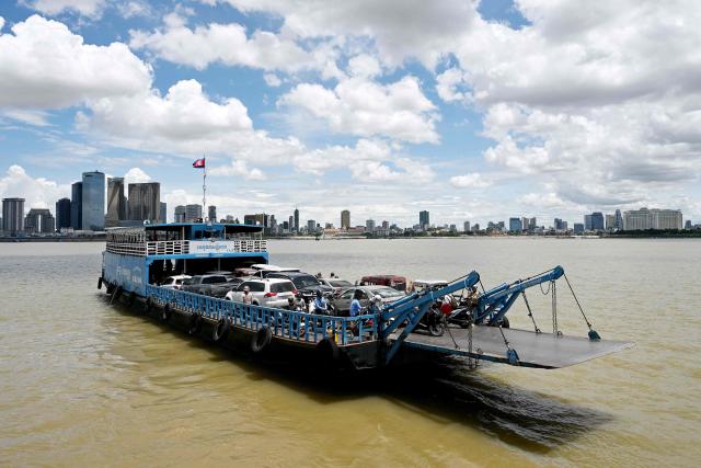 A ferry transports passengers and vehicles across the Mekong River in Phnom Penh on June 29, 2026. (Photo by TANG CHHIN Sothy / AFP)