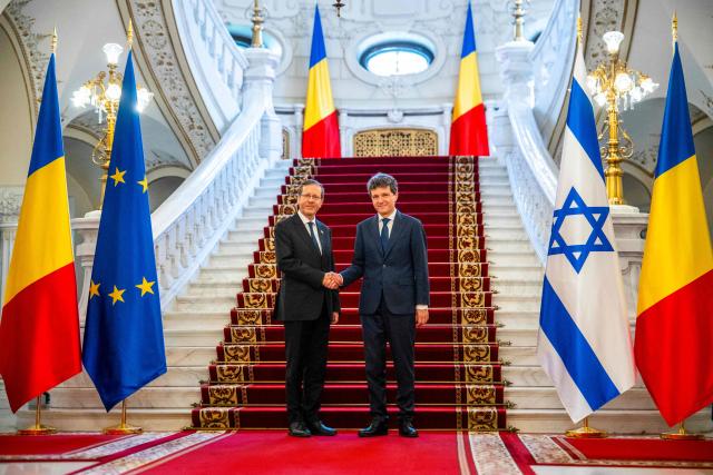 Israeli President Isaac Herzog (L) and Romanian President Nicusor Dan shake hands as they pose for an official photo at the presidential Cotroceni Palace in Bucharest, Romania, on June 29, 2026. (Photo by Mihai Barbu / AFP)