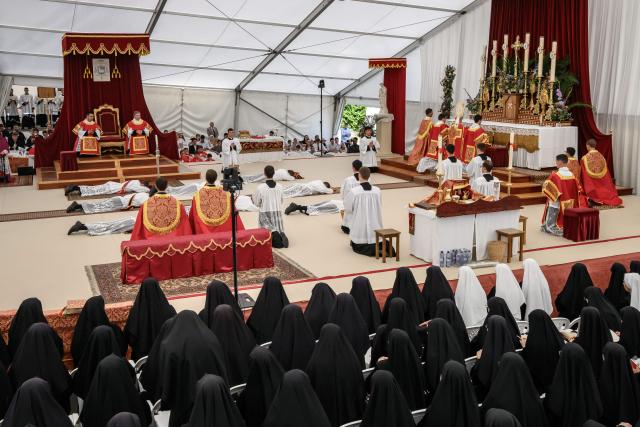 Priests and deacons prostrate themselves during an ordination ceremony of the traditionalist Catholic Society of Saint Pius X (SSPX), in Econe, near Sion, western Switzerland, on June 29, 2026. Defying Vatican, Society of Saint Pius X will ordain its own bishops on July 1, 2026, despite the risk of being considered schismatic. (Photo by Fabrice COFFRINI / AFP)