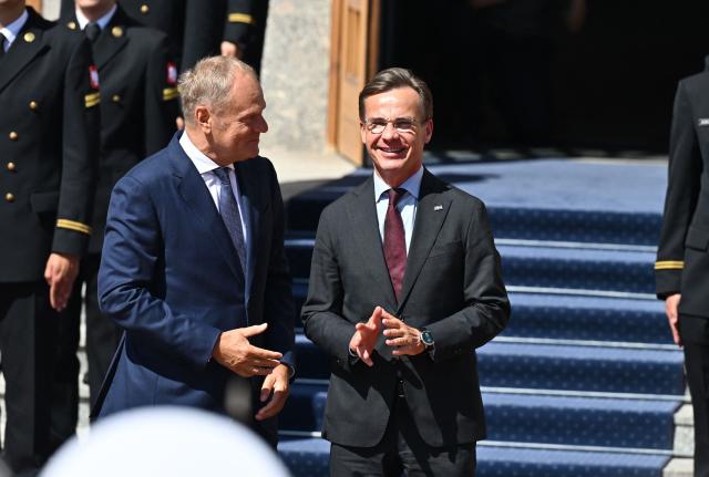 Polish Prime Minister Donald Tusk (L) and Sweden's Prime Minister Ulf Kristersson react during an official welcome ceremony on June 29, 2026 in Gdynia, Poland. Sweden's Prime Minister Ulf Kristersson and several of his ministers travelled to Gdynia, Poland for intergovernmental consultations. The focus will be on strengthened bilateral cooperation between Sweden and Poland, specifically with regard to regional security and defence. (Photo by Marcin Gadomski / AFP)