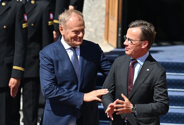 Polish Prime Minister Donald Tusk (L) and Sweden's Prime Minister Ulf Kristersson react during an official welcome ceremony on June 29, 2026 in Gdynia, Poland. Sweden's Prime Minister Ulf Kristersson and several of his ministers travelled to Gdynia, Poland for intergovernmental consultations. The focus will be on strengthened bilateral cooperation between Sweden and Poland, specifically with regard to regional security and defence. (Photo by Marcin Gadomski / AFP)