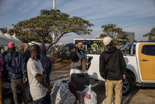 Undocumented migrants line up outside the Durban Drive In in Durban, on June 29, 2026. Authorities refused to take in more undocumented migrants after the operation in Durban was shut down and transferred to the border with Zimbabwe. Migrants will have to make their way to the border paying from their pockets. (Photo by MARCO LONGARI / AFP)