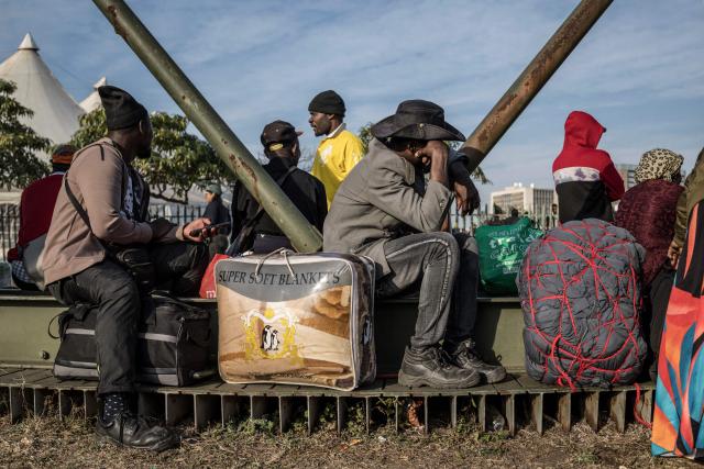 Undocumented migrants line up outside the Durban Drive In in Durban, on June 29, 2026. Authorities refused to take in more undocumented migrants after the operation in Durban was shut down and transferred to the border with Zimbabwe. Migrants will have to make their way to the border paying from their pockets. (Photo by MARCO LONGARI / AFP)