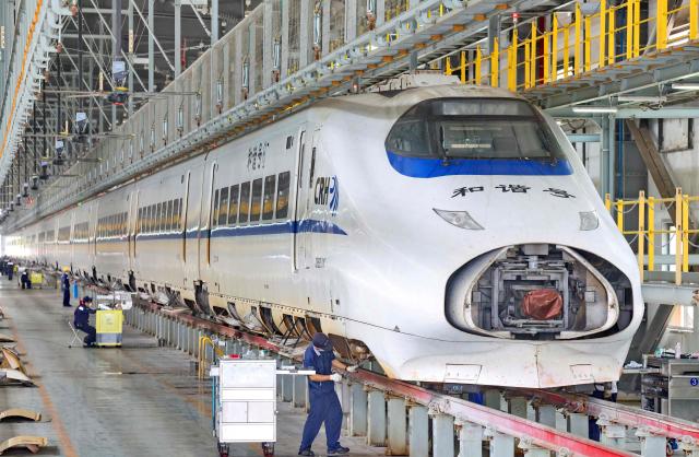 Workers maintain a high-speed train at Nantong High-Speed Train Depot in Nantong, China’s eastern Jiangsu province on June 29, 2026. (Photo by CN-STR / AFP) / China OUT