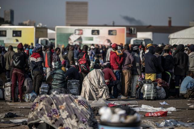 Undocumented migrants line up outside the Durban Drive In in Durban, on June 29, 2026. Authorities refused to take in more undocumented migrants after the operation in Durban was shut down and transferred to the border with Zimbabwe. Migrants will have to make their way to the border paying from their pockets. (Photo by MARCO LONGARI / AFP)