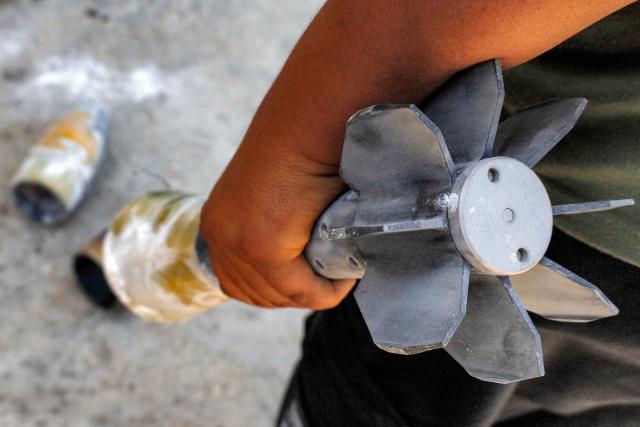 A man holds an unexploded artillery shell that fell during reported overnight Israeli bombardment that hit the village of Abidin in Syria's southwestern Daraa province, close to the Golan Heights, on June 29, 2026. Syria's foreign ministry condemned on June 29 Israeli incursions and shelling in the south of the country, a day after an escalation in the village in Daraa province forced its residents to temporarily flee, according to local officials. (Photo by Sam HARIRI / AFP)