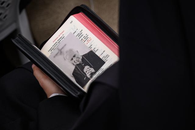 A nun holds a liturgical book showing a photograph of late founder of traditionalist Catholic Society of Saint Pius X, Bishop Marcel Lefebvre, during an ordination ceremony of the traditionalist Catholic Society of Saint Pius X (SSPX), in Econe, near Sion, western Switzerland, on June 29, 2026. Defying Vatican, Society of Saint Pius X will ordain its own bishops on July 1, 2026, despite the risk of being considered schismatic. (Photo by Fabrice COFFRINI / AFP)
