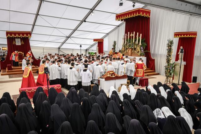 Priests gather around the altar during an ordination ceremony of the traditionalist Catholic Society of Saint Pius X (SSPX), in Econe, near Sion, western Switzerland, on June 29, 2026. Defying Vatican, Society of Saint Pius X will ordain its own bishops on July 1, 2026, despite the risk of being considered schismatic. (Photo by Fabrice COFFRINI / AFP)