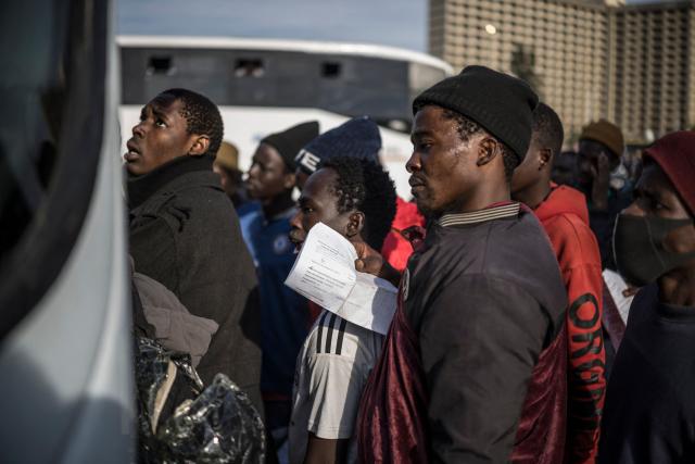 Undocumented migrants queue to board a bus at the Durban Drive In in Durban, on June 29, 2026 preparing to leave before the camp will shut down and the operation will be transferred to the border with Zimbabwe. South Africans President Cyril Ramaphosa vowed on June 25 to crush any attempts to destabilise the nation during planned anti-immigrant marches next week, amid a wave of xenophobia. Citizen-led groups have set Tuesday 30 as a deadline for undocumented foreigners to leave and called for nationwide marches against illegal immigration, marking a crescendo in months of protests that have at times turned violent. (Photo by MARCO LONGARI / AFP)