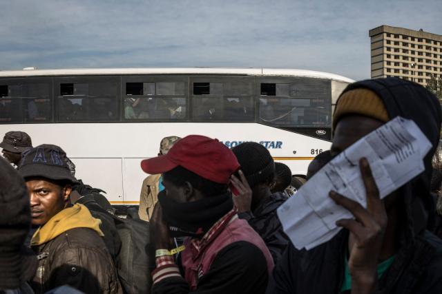Undocumented migrants queue to board a bus at the Durban Drive In in Durban, on June 29, 2026 preparing to leave before the camp will shut down and the operation will be transferred to the border with Zimbabwe. South Africans President Cyril Ramaphosa vowed on June 25 to crush any attempts to destabilise the nation during planned anti-immigrant marches next week, amid a wave of xenophobia. Citizen-led groups have set Tuesday 30 as a deadline for undocumented foreigners to leave and called for nationwide marches against illegal immigration, marking a crescendo in months of protests that have at times turned violent. (Photo by MARCO LONGARI / AFP)