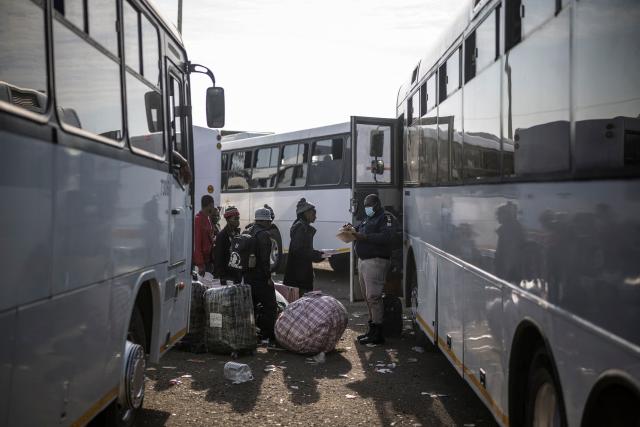 A South African Immigration official checks the names of undocumented migrants queueing to board busses at the Durban Drive In in Durban, on June 29, 2026 preparing to leave before the camp will shut down and the operation will be transferred to the border with Zimbabwe. South Africans President Cyril Ramaphosa vowed on June 25 to crush any attempts to destabilise the nation during planned anti-immigrant marches next week, amid a wave of xenophobia. Citizen-led groups have set Tuesday 30 as a deadline for undocumented foreigners to leave and called for nationwide marches against illegal immigration, marking a crescendo in months of protests that have at times turned violent. (Photo by MARCO LONGARI / AFP)