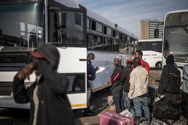 A South African Immigration official checks the names of undocumented migrants queueing to board busses at the Durban Drive In in Durban, on June 29, 2026 preparing to leave before the camp will shut down and the operation will be transferred to the border with Zimbabwe. South Africans President Cyril Ramaphosa vowed on June 25 to crush any attempts to destabilise the nation during planned anti-immigrant marches next week, amid a wave of xenophobia. Citizen-led groups have set Tuesday 30 as a deadline for undocumented foreigners to leave and called for nationwide marches against illegal immigration, marking a crescendo in months of protests that have at times turned violent. (Photo by MARCO LONGARI / AFP)
