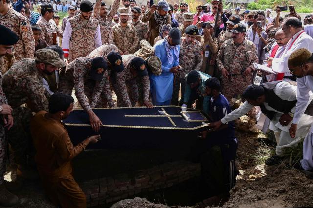 Pakistani Rangers bury the coffin of a paramilitary soldier killed in a terror attack during his funeral in Hyderabad, Sindh province, on June 29, 2026. Three Pakistani Rangers were killed in a terror attack in the southern megacity Karachi on June 27 evening, the country's military said, following an explosion and heavy gunfire. (Photo by Akram SHAHID / AFP)