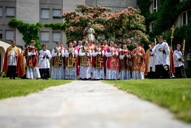 Priests and deacons pose next to a statue of Saint Pius X after an ordination ceremony of the traditionalist Catholic Society of Saint Pius X (SSPX), in Econe, near Sion, western Switzerland, on June 29, 2026. Defying Vatican, Society of Saint Pius X will ordain its own bishops on July 1, 2026, despite the risk of being considered schismatic. (Photo by Fabrice COFFRINI / AFP)