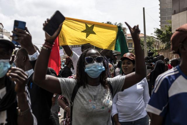 A protester holds a Senegalese national flag during a demonstration against a constitutional reform bill near the National Assembly in Dakar, on June 29, 2026. Senegal’s National Assembly was examining, in a tense atmosphere marked by heated exchanges between lawmakers and clashes between demonstrators and police outside the building, a bill revising the Constitution concerning the powers of the President, Parliament, and the Prime Minister. The initiative, put forward by the parliamentary majority and its leader Ousmane Sonko, comes amid a deep disagreement with the country’s president. (Photo by PATRICK MEINHARDT / AFP)