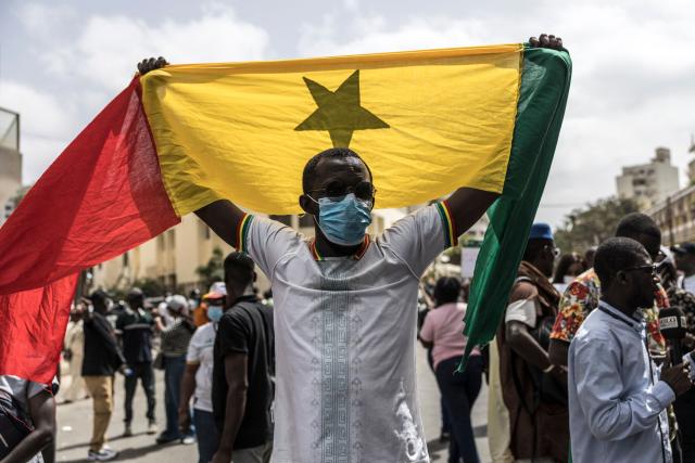 A protester holds a Senegalese national flag during a demonstration against a constitutional reform bill near the National Assembly in Dakar, on June 29, 2026. Senegal’s National Assembly was examining, in a tense atmosphere marked by heated exchanges between lawmakers and clashes between demonstrators and police outside the building, a bill revising the Constitution concerning the powers of the President, Parliament, and the Prime Minister. The initiative, put forward by the parliamentary majority and its leader Ousmane Sonko, comes amid a deep disagreement with the country’s president. (Photo by PATRICK MEINHARDT / AFP)