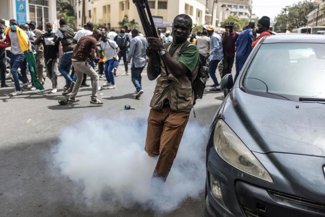 A member of the media runs for cover after Senegalese police officers threw a teargas canister during a demonstration against a constitutional reform bill near the National Assembly in Dakar, on June 29, 2026. Senegal’s National Assembly was examining, in a tense atmosphere marked by heated exchanges between lawmakers and clashes between demonstrators and police outside the building, a bill revising the Constitution concerning the powers of the President, Parliament, and the Prime Minister. The initiative, put forward by the parliamentary majority and its leader Ousmane Sonko, comes amid a deep disagreement with the country’s president. (Photo by PATRICK MEINHARDT / AFP)