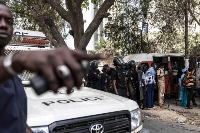 A Senegalese police officer holding a teargas canister gestures during a demonstration against a constitutional reform bill near the National Assembly in Dakar, on June 29, 2026. Senegal’s National Assembly was examining, in a tense atmosphere marked by heated exchanges between lawmakers and clashes between demonstrators and police outside the building, a bill revising the Constitution concerning the powers of the President, Parliament, and the Prime Minister. The initiative, put forward by the parliamentary majority and its leader Ousmane Sonko, comes amid a deep disagreement with the country’s president. (Photo by PATRICK MEINHARDT / AFP)