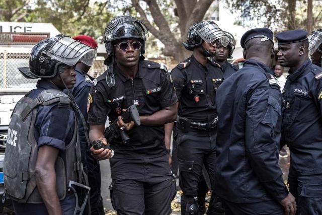 A Senegalese police officer wearing riot gear prepares to throw a teargas canister during a demonstration against a constitutional reform bill near the National Assembly in Dakar, on June 29, 2026. Senegal’s National Assembly was examining, in a tense atmosphere marked by heated exchanges between lawmakers and clashes between demonstrators and police outside the building, a bill revising the Constitution concerning the powers of the President, Parliament, and the Prime Minister. The initiative, put forward by the parliamentary majority and its leader Ousmane Sonko, comes amid a deep disagreement with the country’s president. (Photo by PATRICK MEINHARDT / AFP)