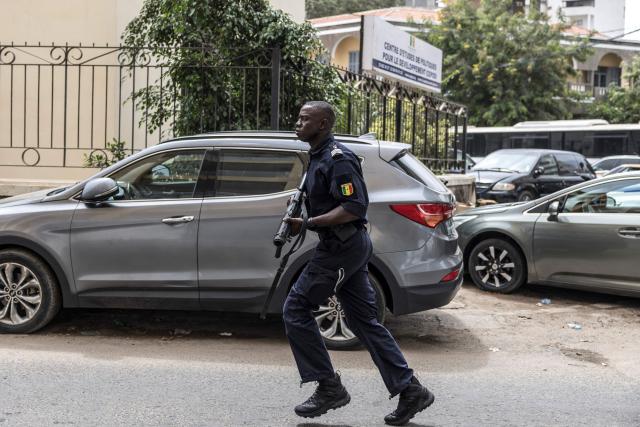 A Senegalese police officers runs with a grenade launcher loaded with teargas during a demonstration against a constitutional reform bill near the National Assembly in Dakar, on June 29, 2026. Senegal’s National Assembly was examining, in a tense atmosphere marked by heated exchanges between lawmakers and clashes between demonstrators and police outside the building, a bill revising the Constitution concerning the powers of the President, Parliament, and the Prime Minister. The initiative, put forward by the parliamentary majority and its leader Ousmane Sonko, comes amid a deep disagreement with the country’s president. (Photo by PATRICK MEINHARDT / AFP)