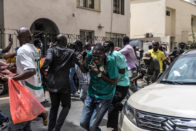 People run for cover after Senegalese police officers fired a teargas canister during a demonstration against a constitutional reform bill near the National Assembly in Dakar, on June 29, 2026. Senegal’s National Assembly was examining, in a tense atmosphere marked by heated exchanges between lawmakers and clashes between demonstrators and police outside the building, a bill revising the Constitution concerning the powers of the President, Parliament, and the Prime Minister. The initiative, put forward by the parliamentary majority and its leader Ousmane Sonko, comes amid a deep disagreement with the country’s president. (Photo by PATRICK MEINHARDT / AFP)