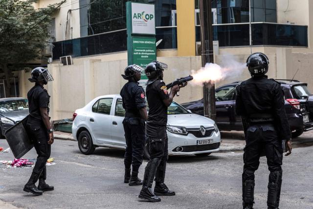 A Senegalese police officer fires a teargas canister during a demonstration against a constitutional reform bill near the National Assembly in Dakar, on June 29, 2026. Senegal’s National Assembly was examining, in a tense atmosphere marked by heated exchanges between lawmakers and clashes between demonstrators and police outside the building, a bill revising the Constitution concerning the powers of the President, Parliament, and the Prime Minister. The initiative, put forward by the parliamentary majority and its leader Ousmane Sonko, comes amid a deep disagreement with the country’s president. (Photo by PATRICK MEINHARDT / AFP)