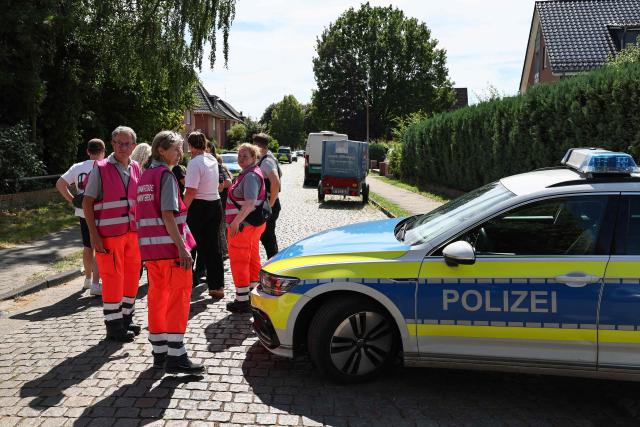 Police and members of a crisis intervention team speak to people near the scene where five people were killed in a shooting in Stade, northern Germany, a city some 50 kilometres west of Hamburg, on June 29, 2026. German police said five people were killed and others injured on June 29, 2026 in a shooting in a youth welfare facility in the northern city of Stade. Two people were arrested, including the suspected shooter, and there was now "no danger to the public", local police said in an update around 1215 GMT. (Photo by Ibrahim OT / AFP)