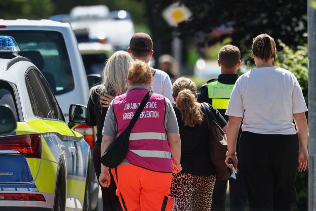 Police and members of a crisis intervention team accompany people near the scene where five people were killed in a shooting in Stade, northern Germany, a city some 50 kilometres west of Hamburg, on June 29, 2026. German police said five people were killed and others injured on June 29, 2026 in a shooting in a youth welfare facility in the northern city of Stade. Two people were arrested, including the suspected shooter, and there was now "no danger to the public", local police said in an update around 1215 GMT. (Photo by Ibrahim OT / AFP)