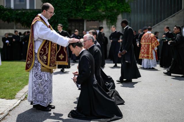 Newly ordained priest Spain's Carlos Hernanz Gallego gives blessings to priests, after an ordination ceremony of the traditionalist Catholic Society of Saint Pius X (SSPX), in Econe, near Sion, western Switzerland, on June 29, 2026. Defying Vatican, Society of Saint Pius X will ordain its own bishops on July 1, 2026, despite the risk of being considered schismatic. (Photo by Fabrice COFFRINI / AFP)
