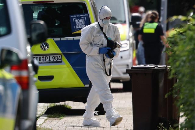 A forensic Police officer with a camera works near the scene where five people were killed in a shooting in Stade, northern Germany, a city some 50 kilometres west of Hamburg, on June 29, 2026. German police said five people were killed and others injured on June 29, 2026 in a shooting in a youth welfare facility in the northern city of Stade. Two people were arrested, including the suspected shooter, and there was now "no danger to the public", local police said in an update around 1215 GMT. (Photo by Ibrahim OT / AFP) / ALTERNATIVE CROP