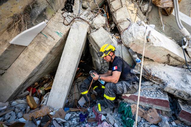 A member of the French 7th Civil Security Training and Intervention Regiment make a recognition with a camara inside a dammaged building in Catia La Mar, La Guaira state, Venezuela, on June 29, 2026. Hopes were fading on June 29, 2026 of finding survivors more than four days after powerful twin earthquakes struck Venezuela, as residents grow increasingly frustrated with the government's response to the disaster that has killed at least 1,450 people and left tens of thousands unaccounted for. (Photo by Miguel MEDINA / POOL / AFP)