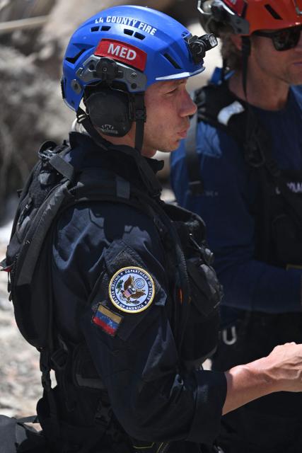 US rescue workers are seen in Caraballeda, La Guaira State, Venezuela on June 29, 2026, following twin earthquakes. Hopes were fading on June 29, 2026 of finding survivors more than four days after powerful twin earthquakes struck Venezuela, as residents grow increasingly frustrated with the government's response to the disaster that has killed at least 1,450 people and left tens of thousands unaccounted for. (Photo by Juan BARRETO / AFP)