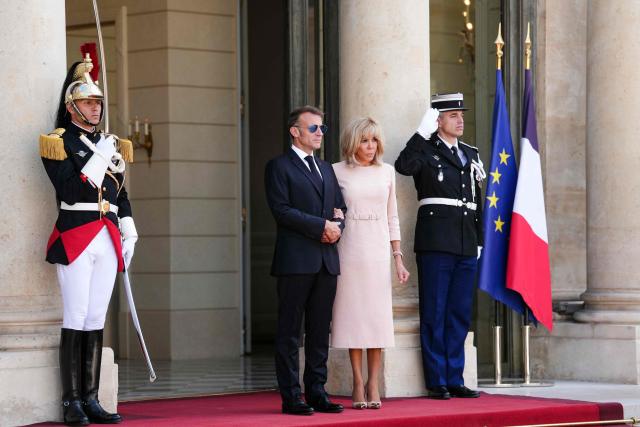 France's President Emmanuel Macron (L) and his wife Brigitte Macron wait to welcome Thailand's King ahead of a meeting at The Elysee Presidential Palace in Paris on June 29, 2026. (Photo by Dimitar DILKOFF / AFP)