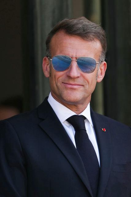 France's President Emmanuel Macron waits to welcome Thailand's King ahead of a meeting at The Elysee Presidential Palace in Paris on June 29, 2026. Emmanuel Macron reappeared wearing now-iconic aviator sunglasses that caused a stir at the Davos forum when he wore them due to an eye condition during a speech. Macron was sporting the blue-tinted shades on the steps of the Elysee Palace. But his eyewear choice wasn't to block the midday sun in Paris, but again because of "an eye problem", staff said, without giving further details. (Photo by Dimitar DILKOFF / AFP)