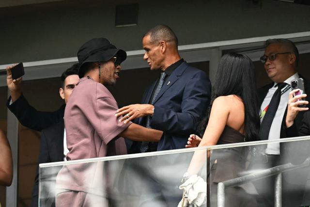 Brazilian former football players Ronaldinho (L) and Rivaldo greet each other as they attend  the 2026 World Cup round of 32 football match between Brazil and Japan at the Houston Stadium in Houston on June 29, 2026.  (Photo by Paul ELLIS / AFP)
