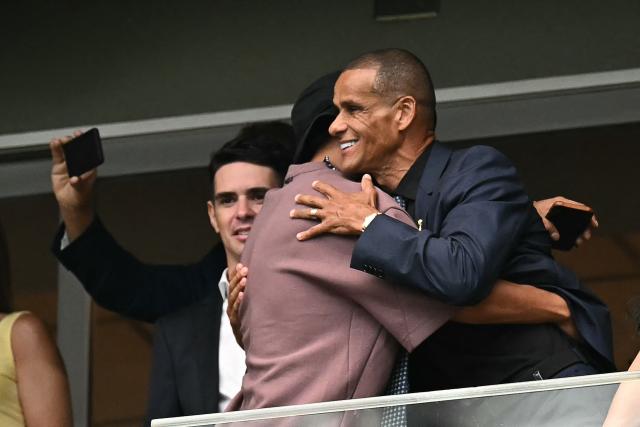 Brazilian former football players Ronaldinho (L) and Rivaldo greet each other as they attend  the 2026 World Cup round of 32 football match between Brazil and Japan at the Houston Stadium in Houston on June 29, 2026.  (Photo by Paul ELLIS / AFP)