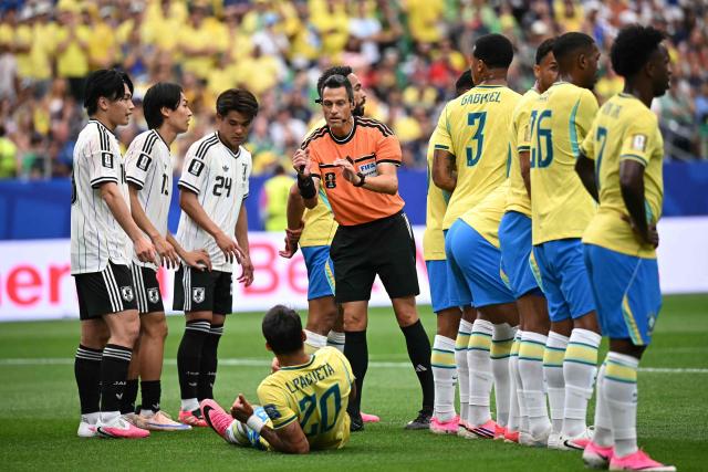 Italian referee Maurizio Mariani (C0 speaks to Brazil's midfielder #20 Lucas Paqueta ahead of a free kick  during the 2026 World Cup round of 32 football match between Brazil and Japan at the Houston Stadium in Houston on June 29, 2026.  (Photo by Paul ELLIS / AFP)