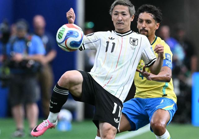 Japan's forward #11 Daizen Maeda (L) fights for the ball with Brazil's defender #04 Marquinhos during the 2026 World Cup round of 32 football match between Brazil and Japan at the Houston Stadium in Houston on June 29, 2026.  (Photo by RONALDO SCHEMIDT / AFP)