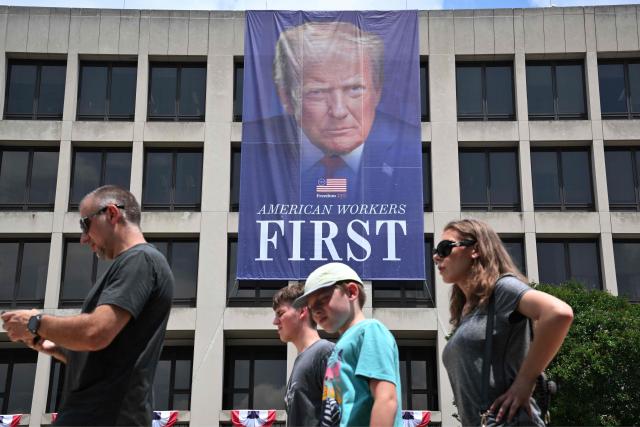 Pedestrians pass by a banner of US President Donald Trump on the side of the US Department of Labor headquarters building in Washington, DC on June 29, 2026. (Photo by Mandel NGAN / AFP)