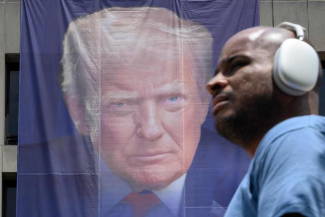 A pedestrian passes by a banner of US President Donald Trump on the side of the US Department of Labor headquarters building in Washington, DC on June 29, 2026. (Photo by Mandel NGAN / AFP)