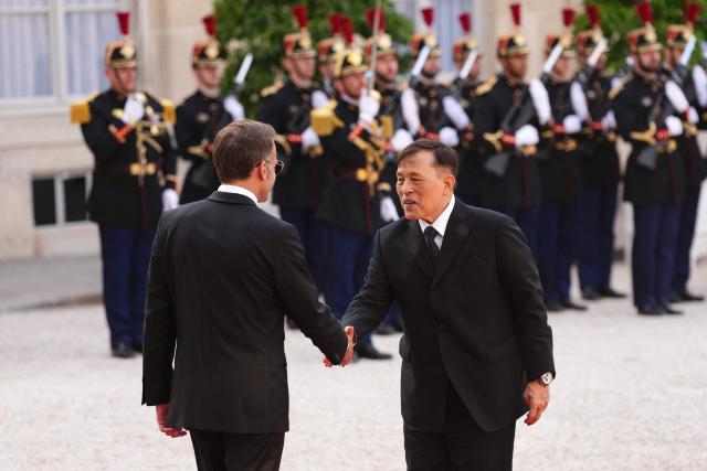 France's President Emmanuel Macron (L) greets Thailand's King Maha Vajiralongkorn (R) as he arrives at The Elysee Presidential Palace for a working dinner as part of the Thai King's State visit to France, in Paris on June 29, 2026. (Photo by Dimitar DILKOFF / AFP)