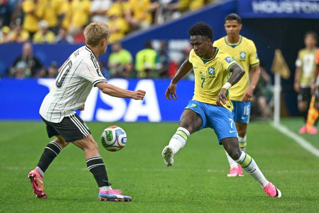 Brazil's forward #07 Vinicius Junior (R) fights for the ball with Japan's midfielder #10 Ritsu Doan  during the 2026 World Cup round of 32 football match between Brazil and Japan at the Houston Stadium in Houston on June 29, 2026.  (Photo by Paul ELLIS / AFP)